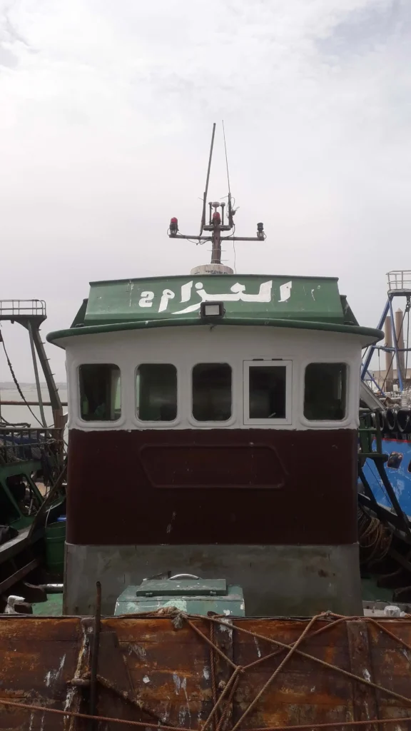 Photo du bateau de pêche traditionnel El Azzam 2 en mer à Essaouira, capturant des poissons frais pour le Restaurant Café El Azzam.