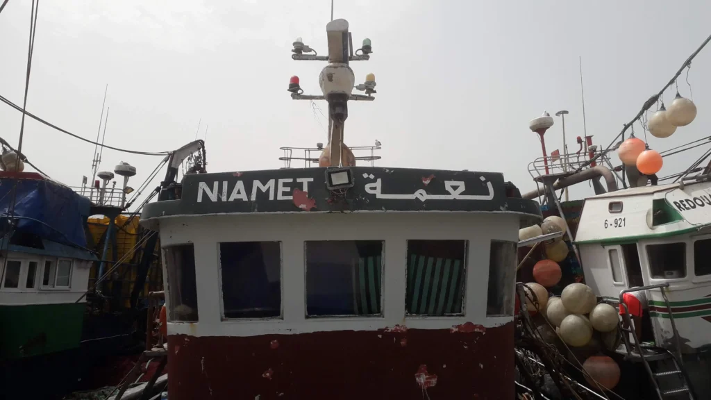 Photo du bateau de pêche traditionnel Niema en mer à Essaouira, capturant des poissons frais pour le Restaurant Café El Azzam.